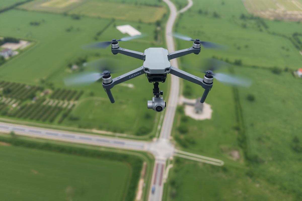 Survey drone with LiDAR sensor flying over terrain